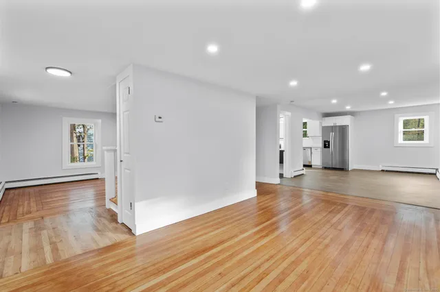 a view of empty room with wooden floor