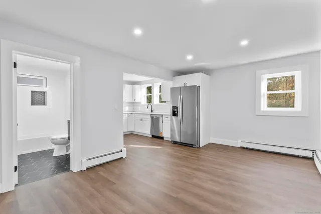 a view of a kitchen with wooden floor and windows