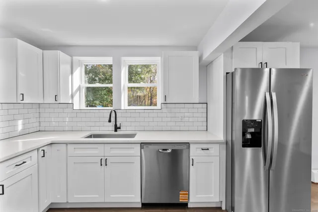 a kitchen with white cabinets and refrigerator