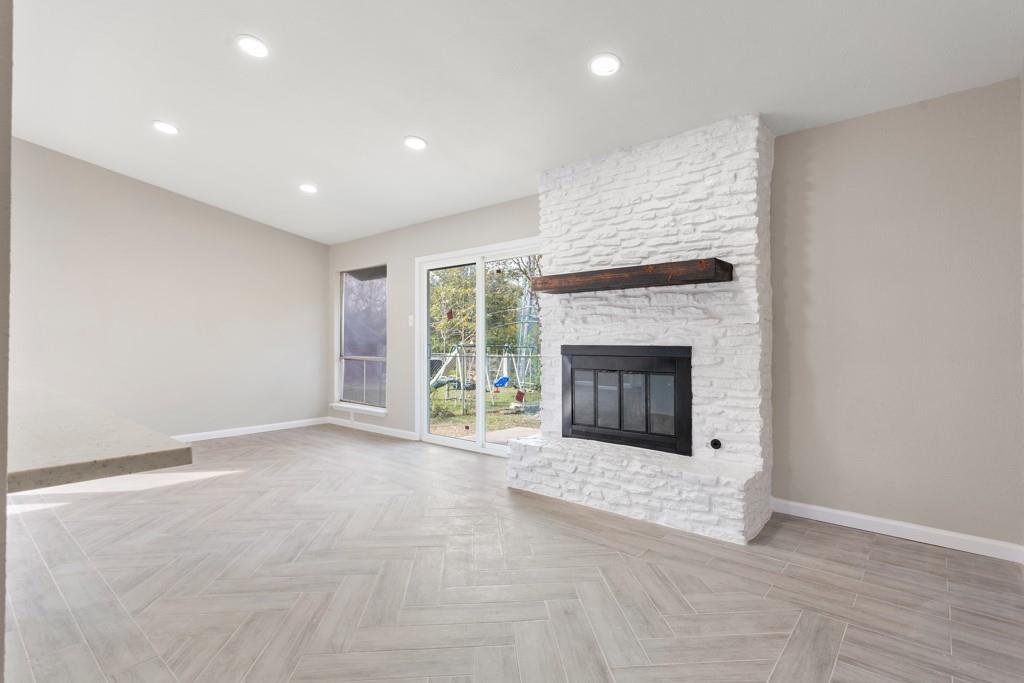 9604 Crown Ridge Road Austin, TX 78753 - Photo 14 of 24 A striking white brick fireplace with a wood mantel serves as the focal point in this open living area.