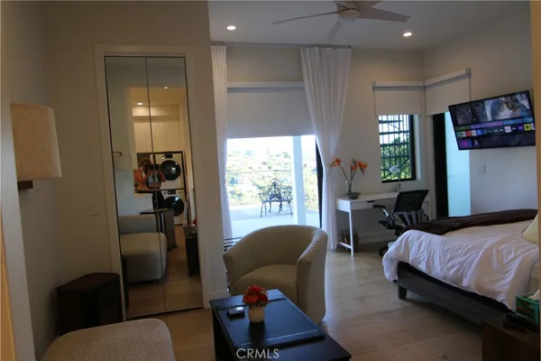 a spacious bedroom with a bed a couch and a large window