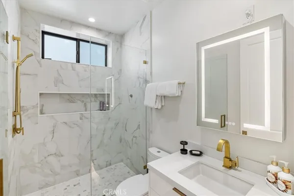a bathroom with a sink a toilet and a mirror