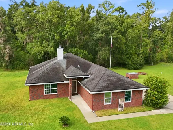 an aerial view of a house with yard porch and furniture