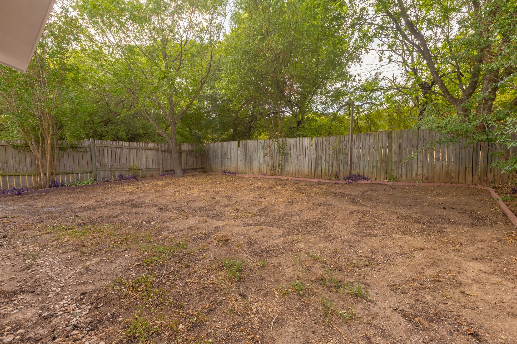 8506 Bisbee Court Austin, TX 78745 - Photo 18 of 20 Expansive backyard featuring a wood privacy fence, mature trees, and a level ground surface
