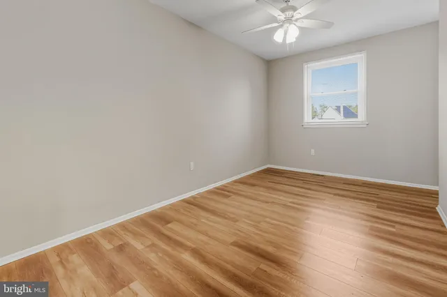 a view of a room with wooden floor and a ceiling fan