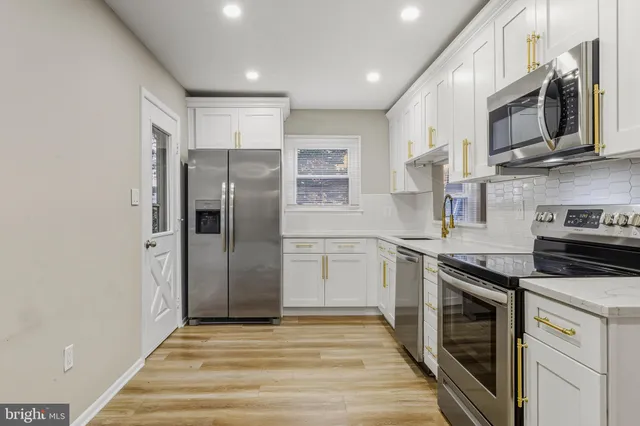 a kitchen with stainless steel appliances granite countertop a refrigerator stove and sink