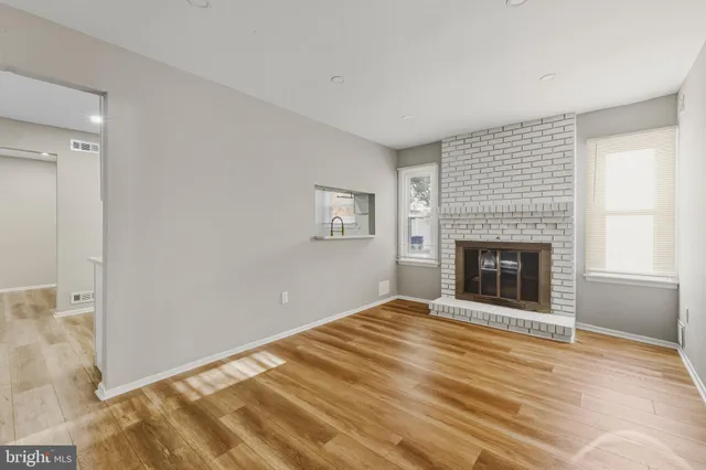 a view of empty room with wooden floor and fireplace
