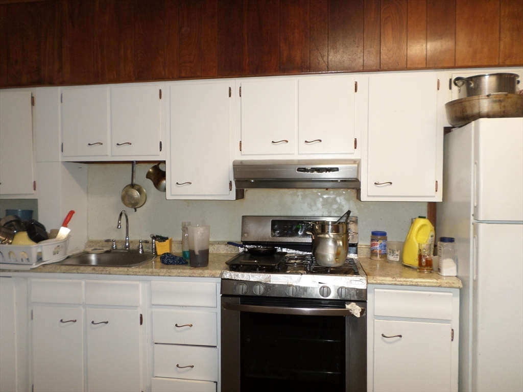 139 Hawthorne Street Chelsea, MA 02150 - Photo 11 of 17 a kitchen with a sink a stove and cabinets