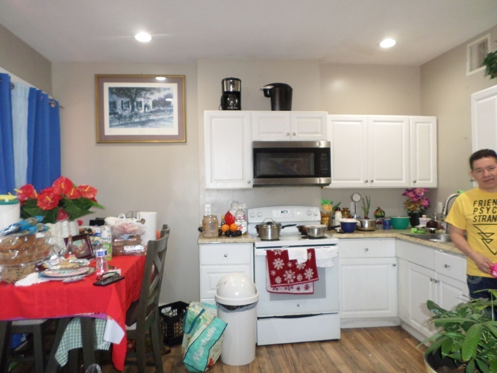 139 Hawthorne Street Chelsea, MA 02150 - Photo 8 of 17 a kitchen with a microwave a stove and cabinets