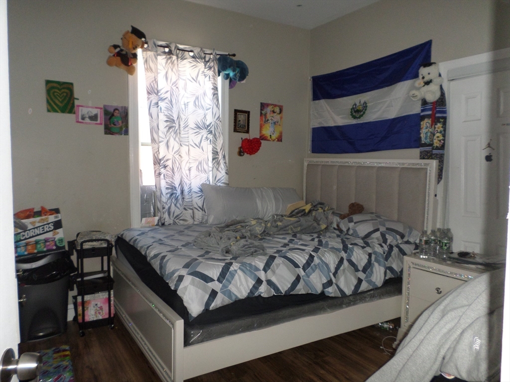 139 Hawthorne Street Chelsea, MA 02150 - Photo 10 of 17 a bed sitting in a bedroom next to a window and a chandelier