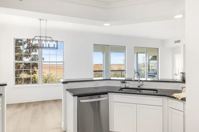 a kitchen with stainless steel appliances granite countertop white cabinets a sink and dishwasher