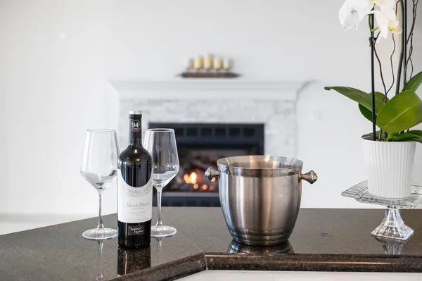 an empty room with wooden floor chandelier and windows