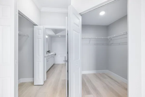 an empty room with wooden floor chandelier fan and windows
