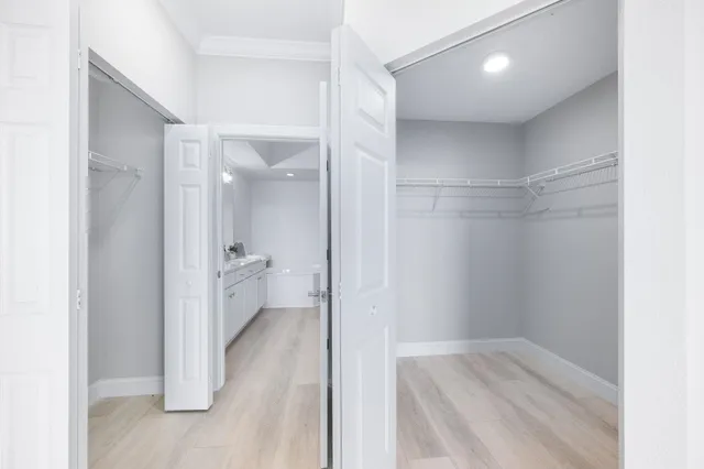 an empty room with wooden floor chandelier fan and windows