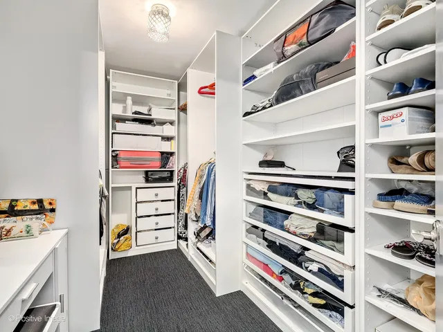 a view of walk in closet with clothes and shoes
