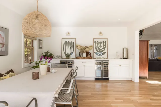 a view of a dining room and livingroom with furniture wooden floor a chandelier