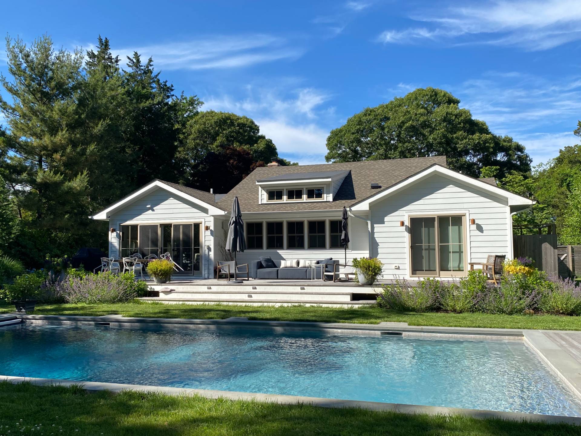 264 Kings Point Road East Hampton, NY 11937 - Photo 23 of 30 a front view of a house with swimming pool yard and outdoor seating