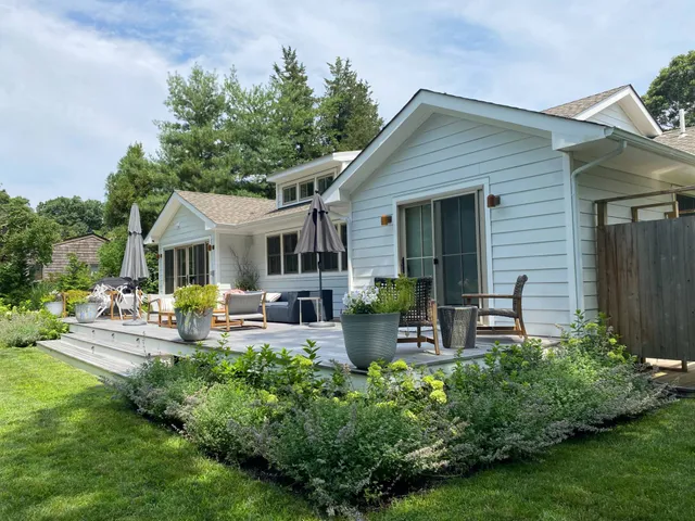 a front view of a house with garden and sitting area