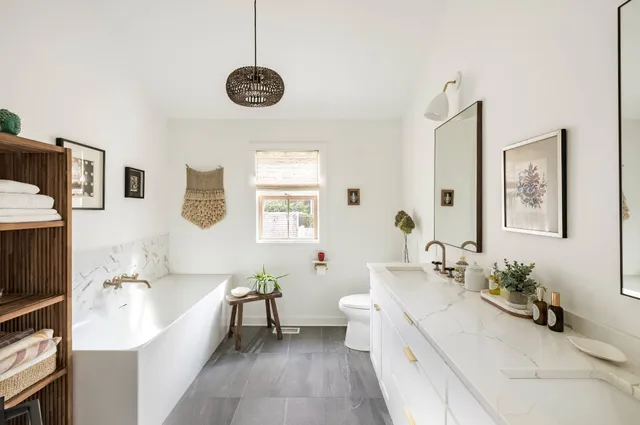 a spacious bathroom with a tub sink and a mirror