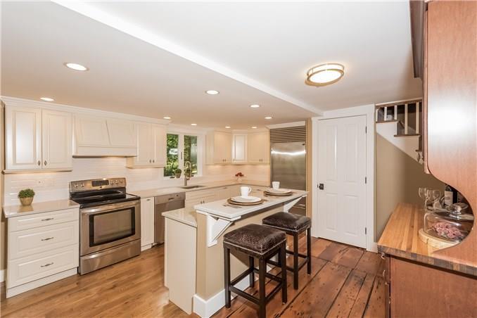 77 Range Road Wilton, CT 06897 - Photo 1 of 1 a kitchen with a sink a stove a refrigerator and white cabinets with wooden floor