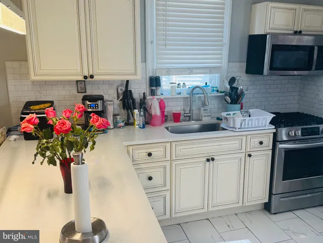 a kitchen with white cabinets and sink