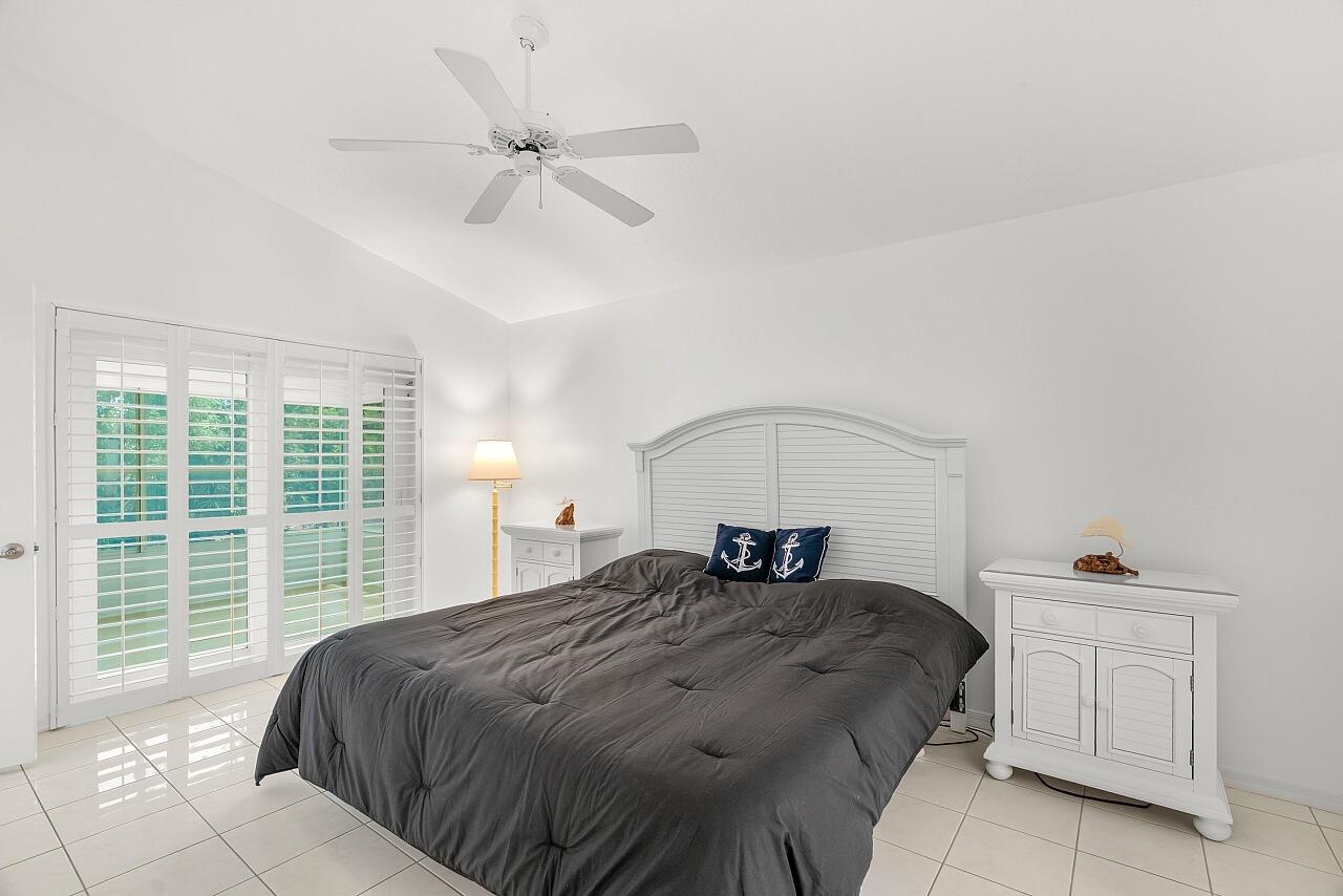 7313 Southeast Seagate Lane Stuart, FL 34997 - Photo 18 of 50 a bedroom with a bed and window