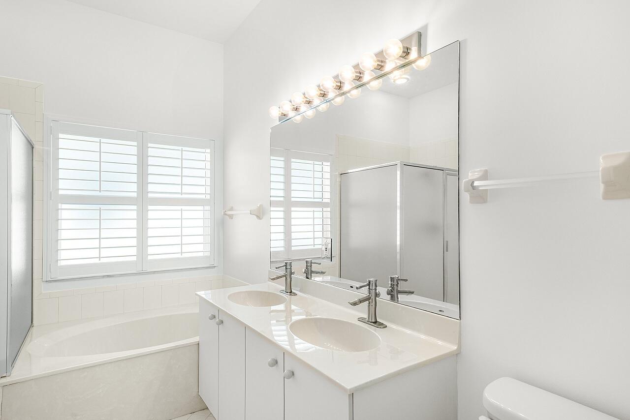 7313 Southeast Seagate Lane Stuart, FL 34997 - Photo 26 of 50 a bathroom with a tub sink and mirror
