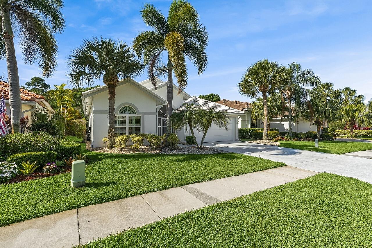 7313 Southeast Seagate Lane Stuart, FL 34997 - Photo 3 of 50 a front view of a house with a garden and palm tree