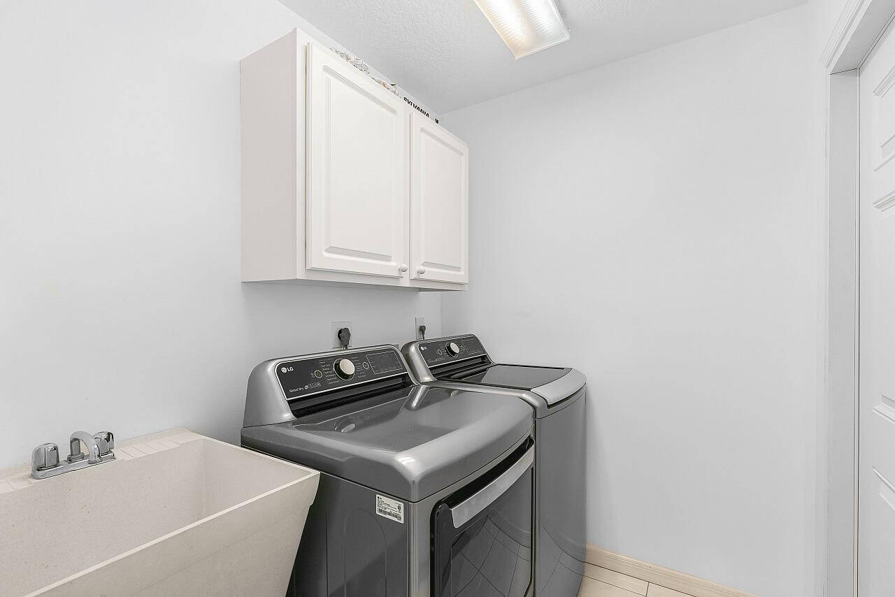 7313 Southeast Seagate Lane Stuart, FL 34997 - Photo 33 of 50 a utility room with a sink a washer and dryer