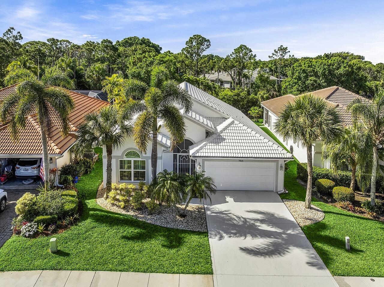 7313 Southeast Seagate Lane Stuart, FL 34997 - Photo 4 of 50 a view of a house with a yard and potted plants