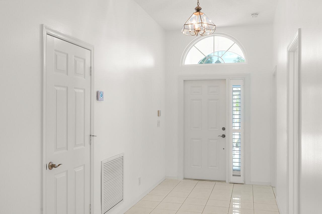 7313 Southeast Seagate Lane Stuart, FL 34997 - Photo 6 of 50 a view of a hallway with wooden floor and front door