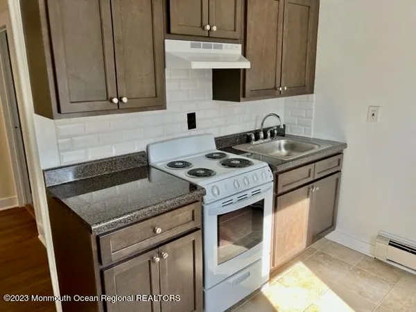 a kitchen with granite countertop a sink stove and cabinets
