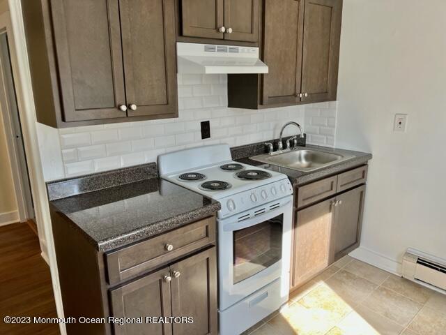 148 B West Sylvania Avenue, Unit B Neptune City, NJ 07753 - Photo 3 of 6 a kitchen with granite countertop a sink stove and cabinets