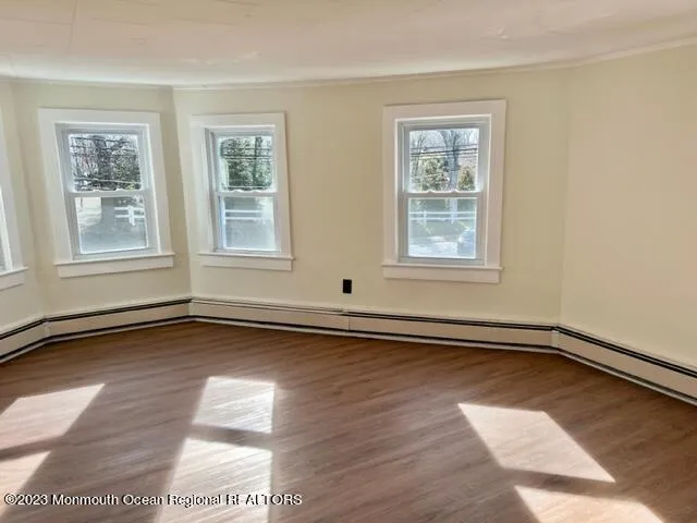 a view of a room with wooden floors and windows