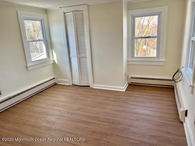 148 B West Sylvania Avenue, Unit B Neptune City, NJ 07753 - Photo 5 of 6 an empty room with wooden floor and windows