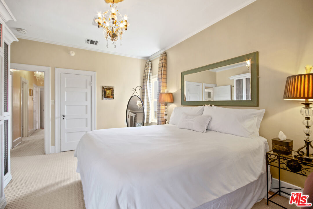 617 North Plymouth Boulevard, Unit 617 1/2 Los Angeles, CA 90004 - Photo 12 of 20 a bedroom with a bed and a chandelier