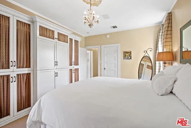 a bedroom with a large bed and wooden floor