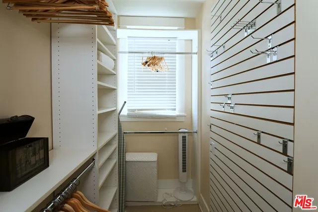 a view of walk in closet with clothes and shoes