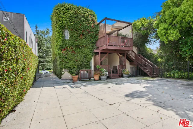a view of a house with a yard and potted plants