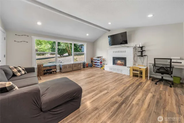 a living room with furniture fireplace and a large window