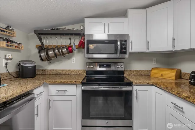 a kitchen with granite countertop cabinets and steel stainless steel appliances