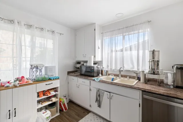a kitchen with stainless steel appliances white cabinets and a refrigerator