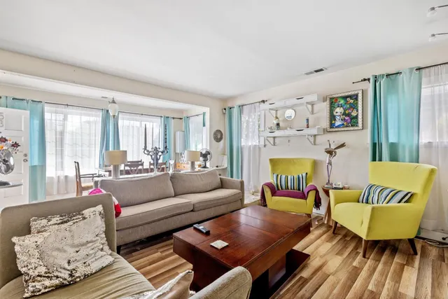 a living room with furniture kitchen view and a dining table