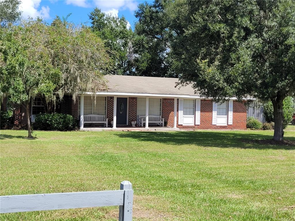 a front view of a house with a yard and trees