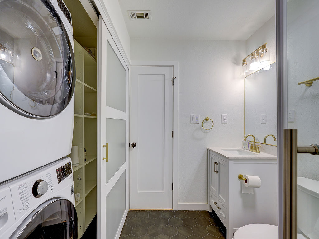 5842 Secrest Drive Austin, TX 78759 - Photo 16 of 40 A well-appointed laundry area with modern appliances and built-in shelving optimizes functionality.