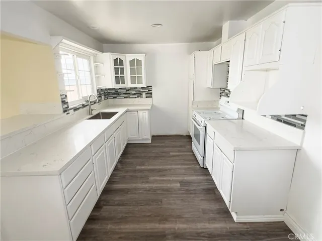 a kitchen with sink a stove and cabinets