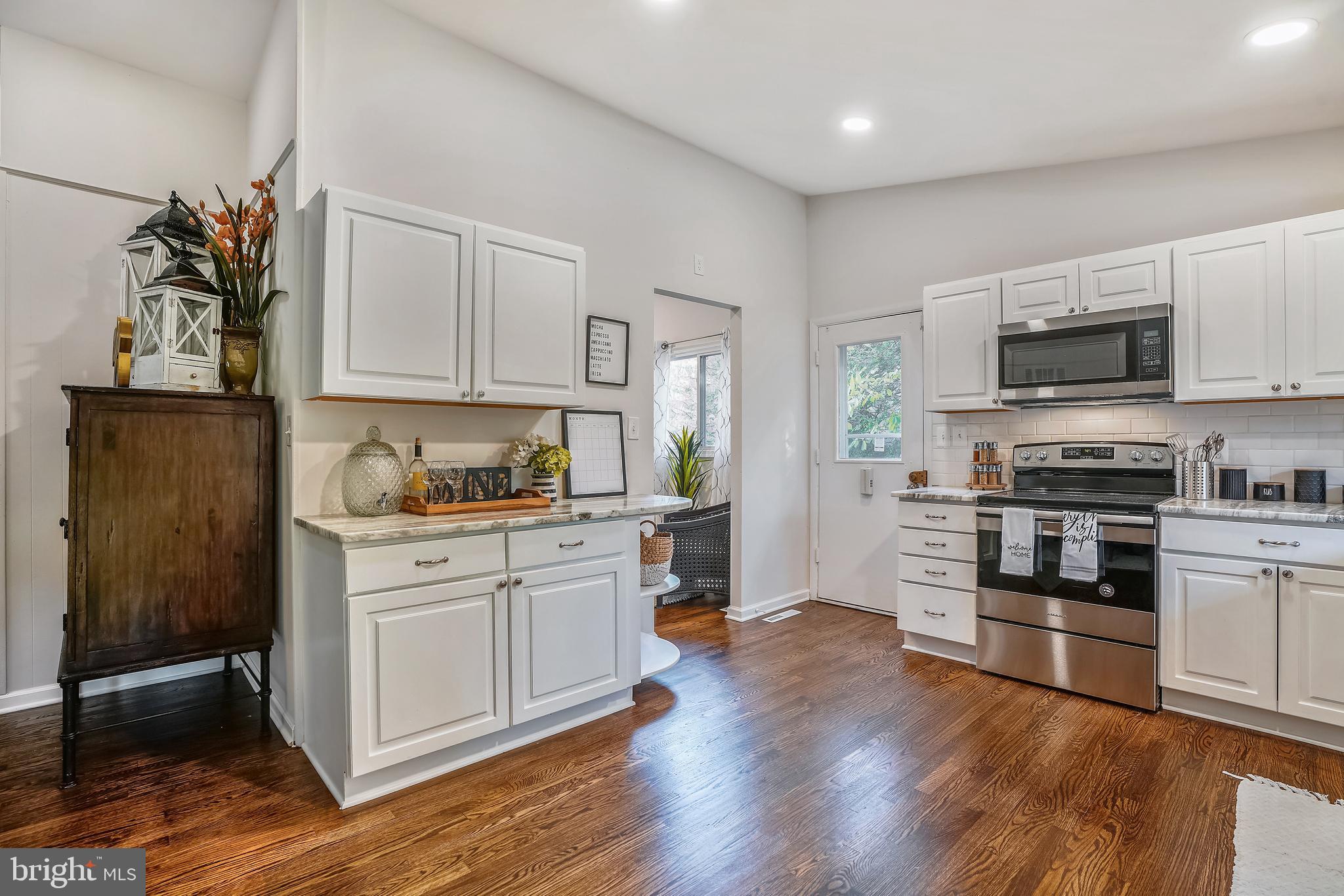 8233 Scotts Level Road Baltimore, MD 21208 - Photo 11 of 37 a kitchen with granite countertop a refrigerator and a stove top oven