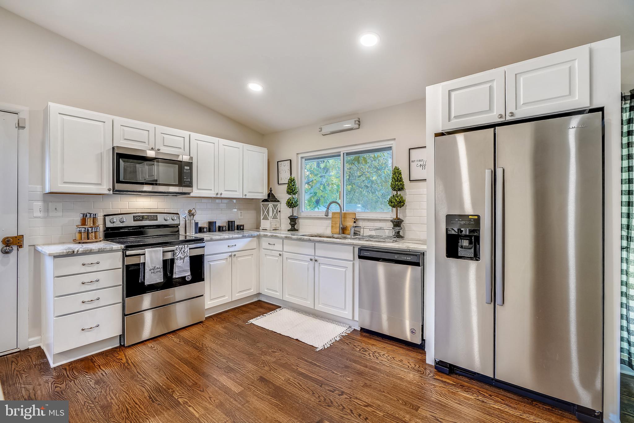 8233 Scotts Level Road Baltimore, MD 21208 - Photo 13 of 37 a kitchen with stainless steel appliances a refrigerator sink and microwave