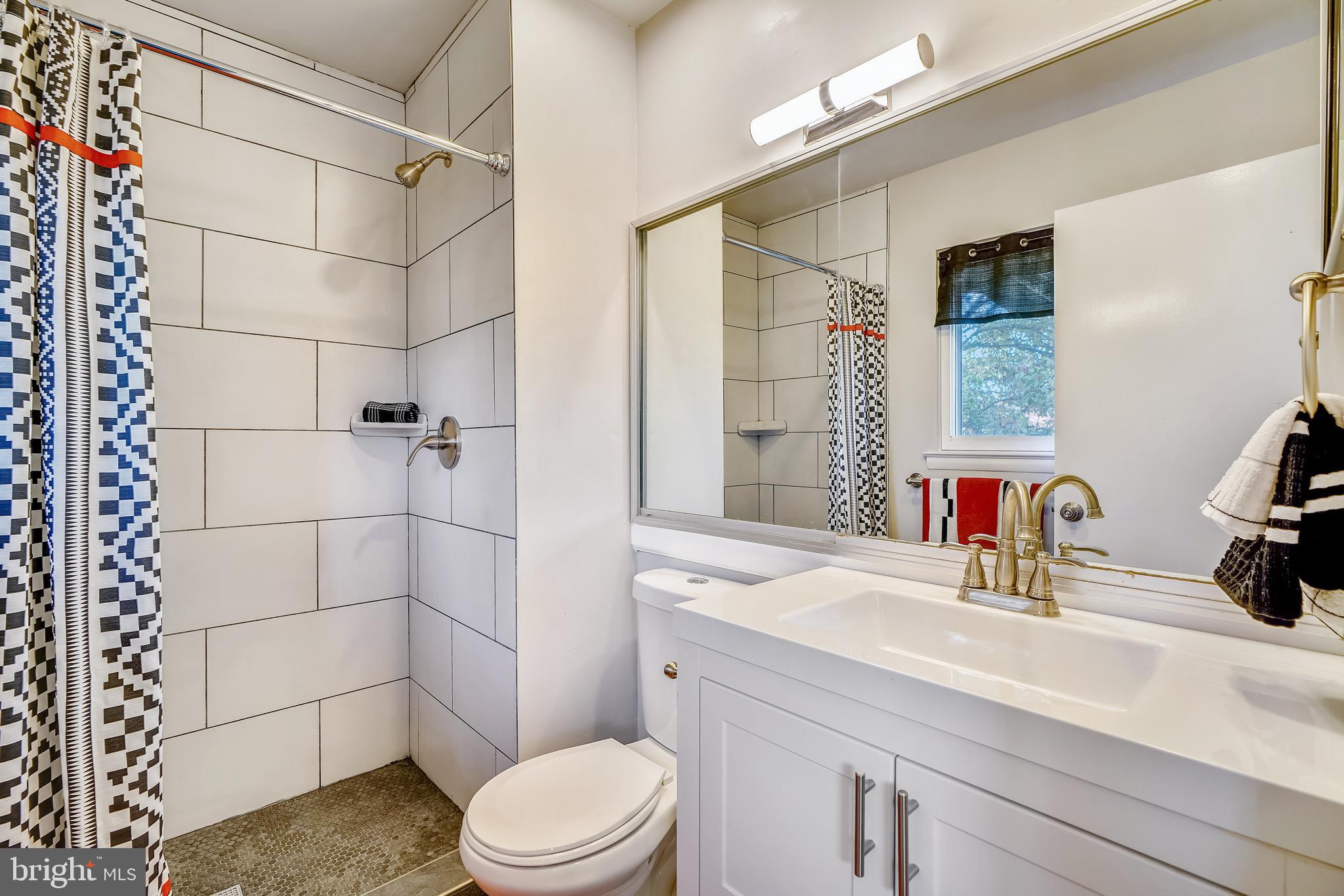 8233 Scotts Level Road Baltimore, MD 21208 - Photo 19 of 37 a bathroom with a sink a toilet and shower