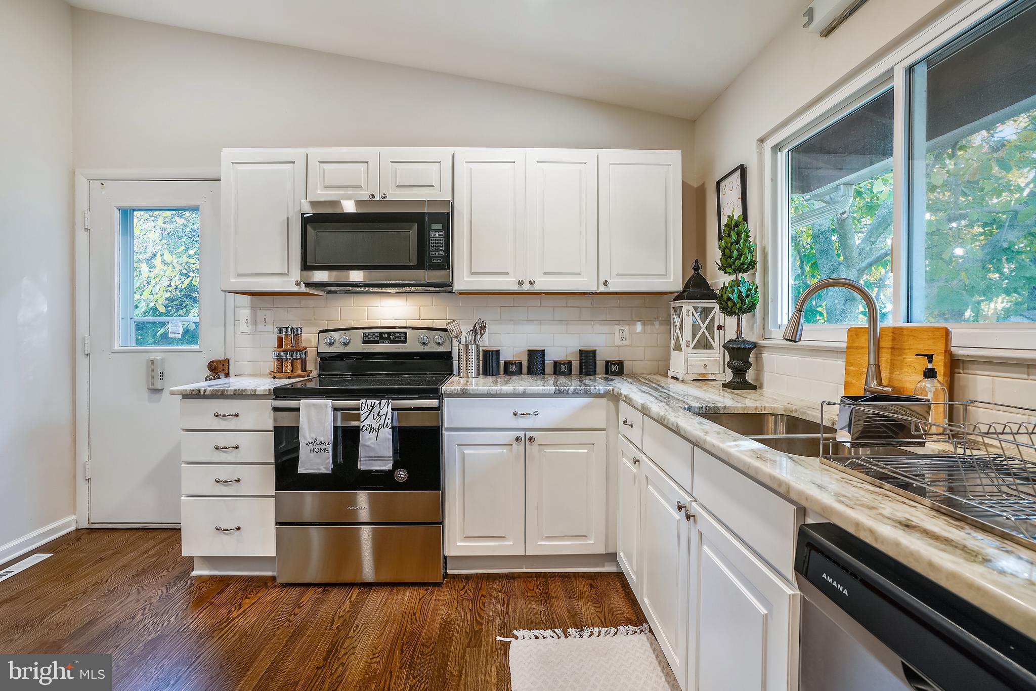 8233 Scotts Level Road Baltimore, MD 21208 - Photo 10 of 37 a kitchen with granite countertop a stove and a sink